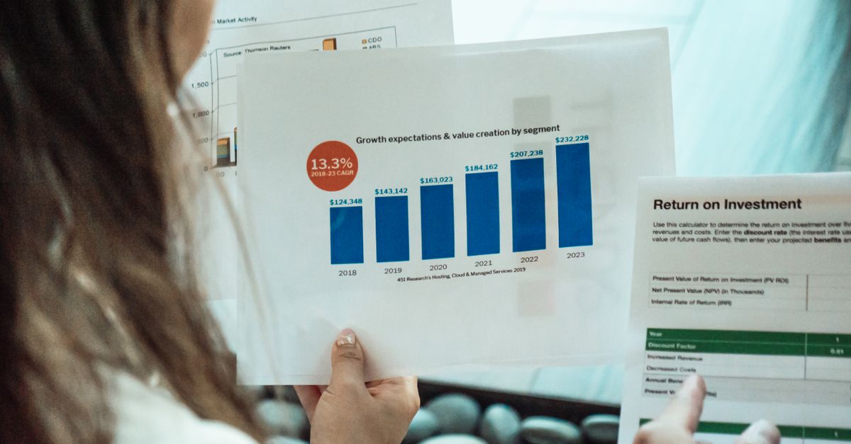 Persona analizando gráficos financieros e informes de ROI, representando la medición de retorno en campañas de marketing